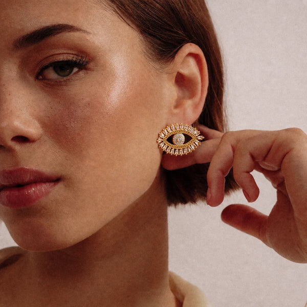 Radiant Nazar Earrings worn by a model in a black top, waterproof gold evil eye earrings