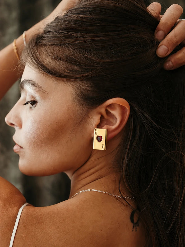 Ace of Hearts Earrings worn by a model in profile, hair pulled back, waterproof gold stud earrings