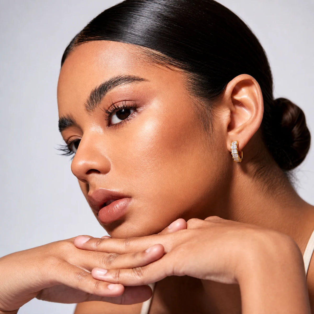 Aurelia Baguette Huggies worn by a model with hair tied back, waterproof gold huggie earrings