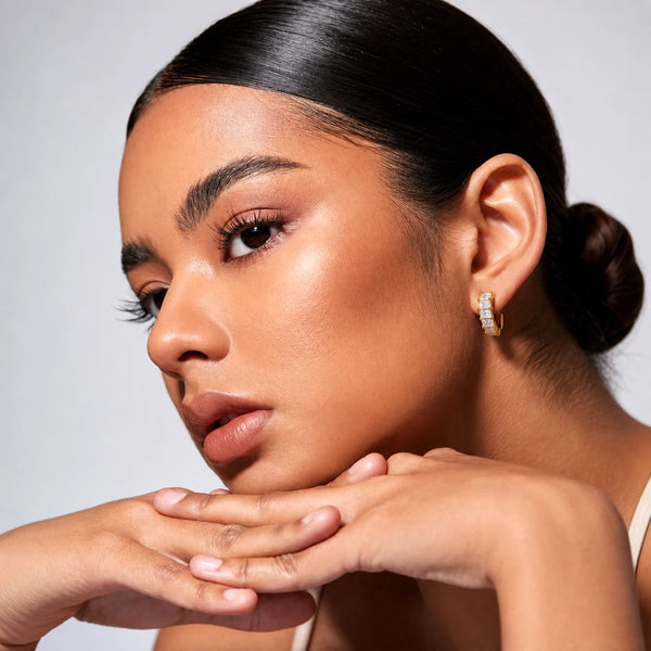 Aurelia Baguette Huggies worn by a model with hair tied back, waterproof gold huggie earrings