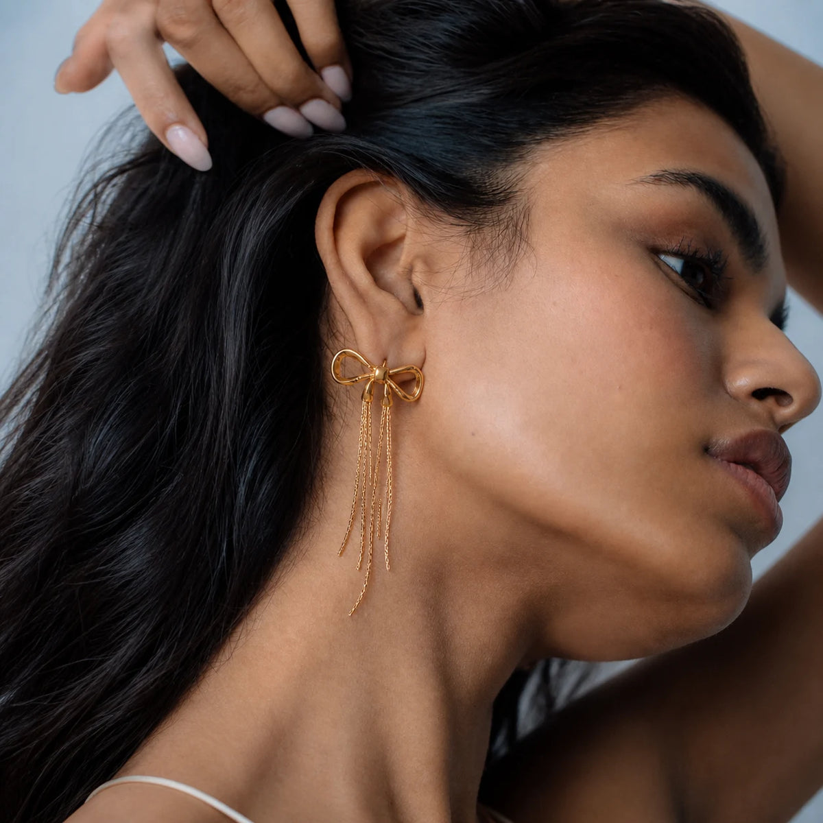 Aurielle Bow Drop Earrings worn by a model, side profile – sweatproof, hypoallergenic drop earrings