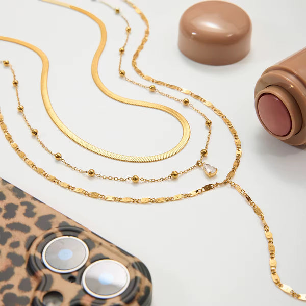 Aurora Layered Necklace – layered necklace styled flat with accessories, 18K gold PVD