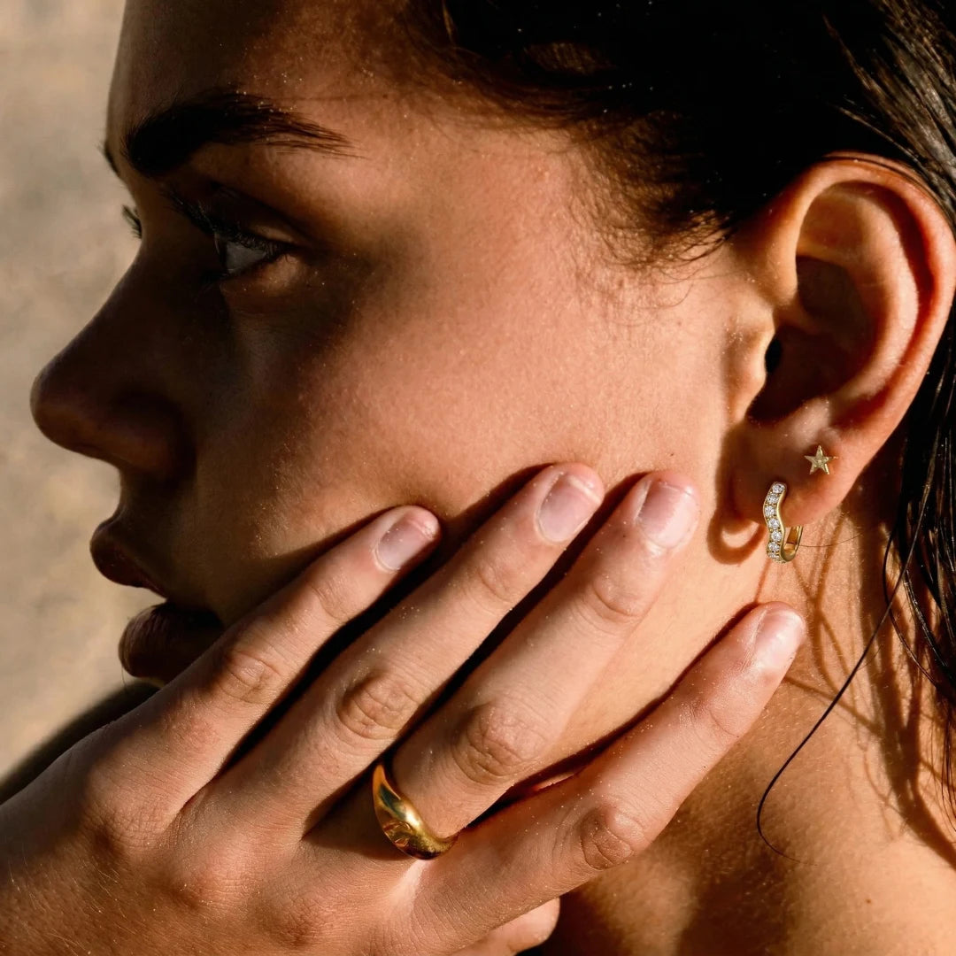 Elara Pavé Hoops worn by a model, hand at the face, 18K gold PVD