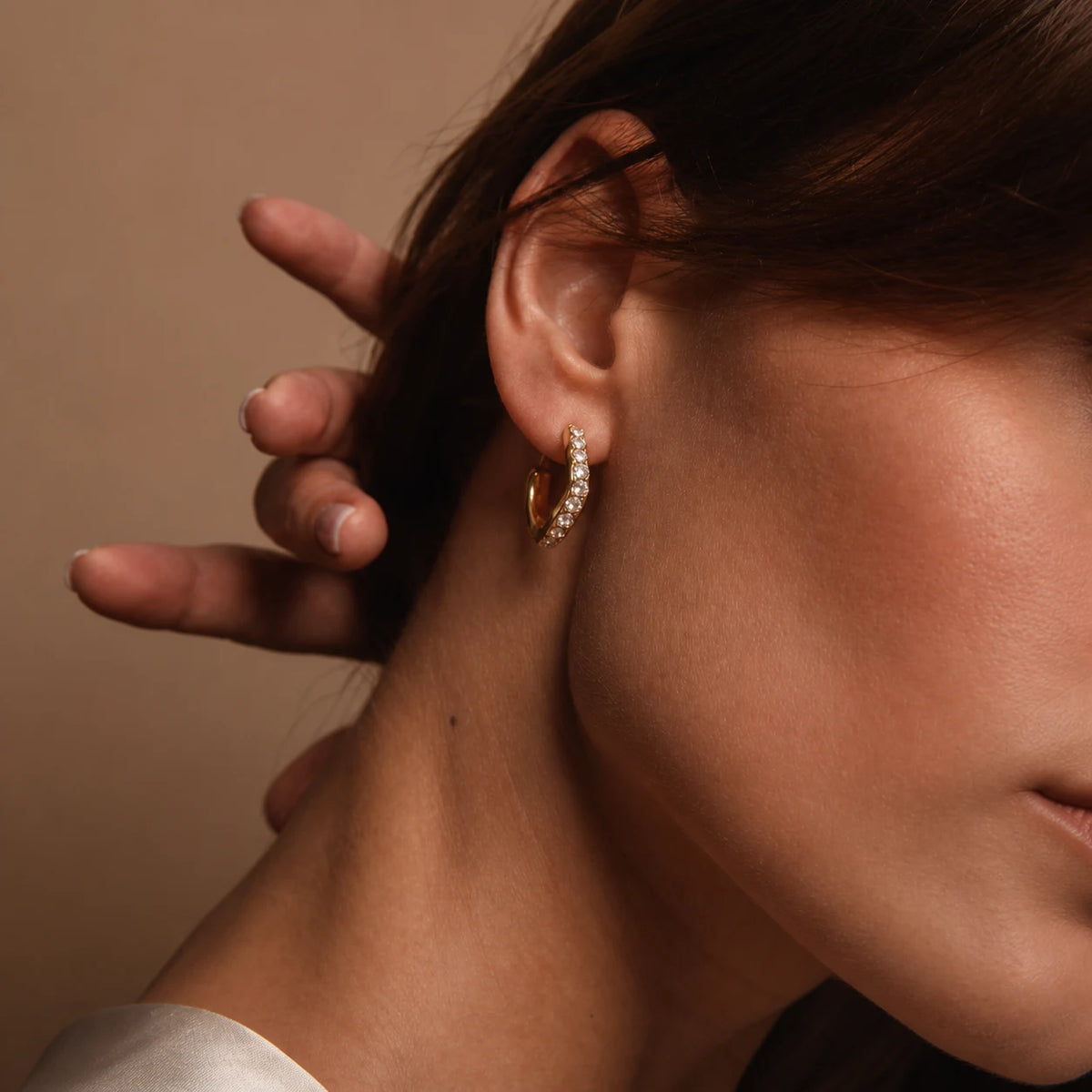 Elara Pavé Hoops worn by a model, side view of the ear, waterproof gold hoop earrings