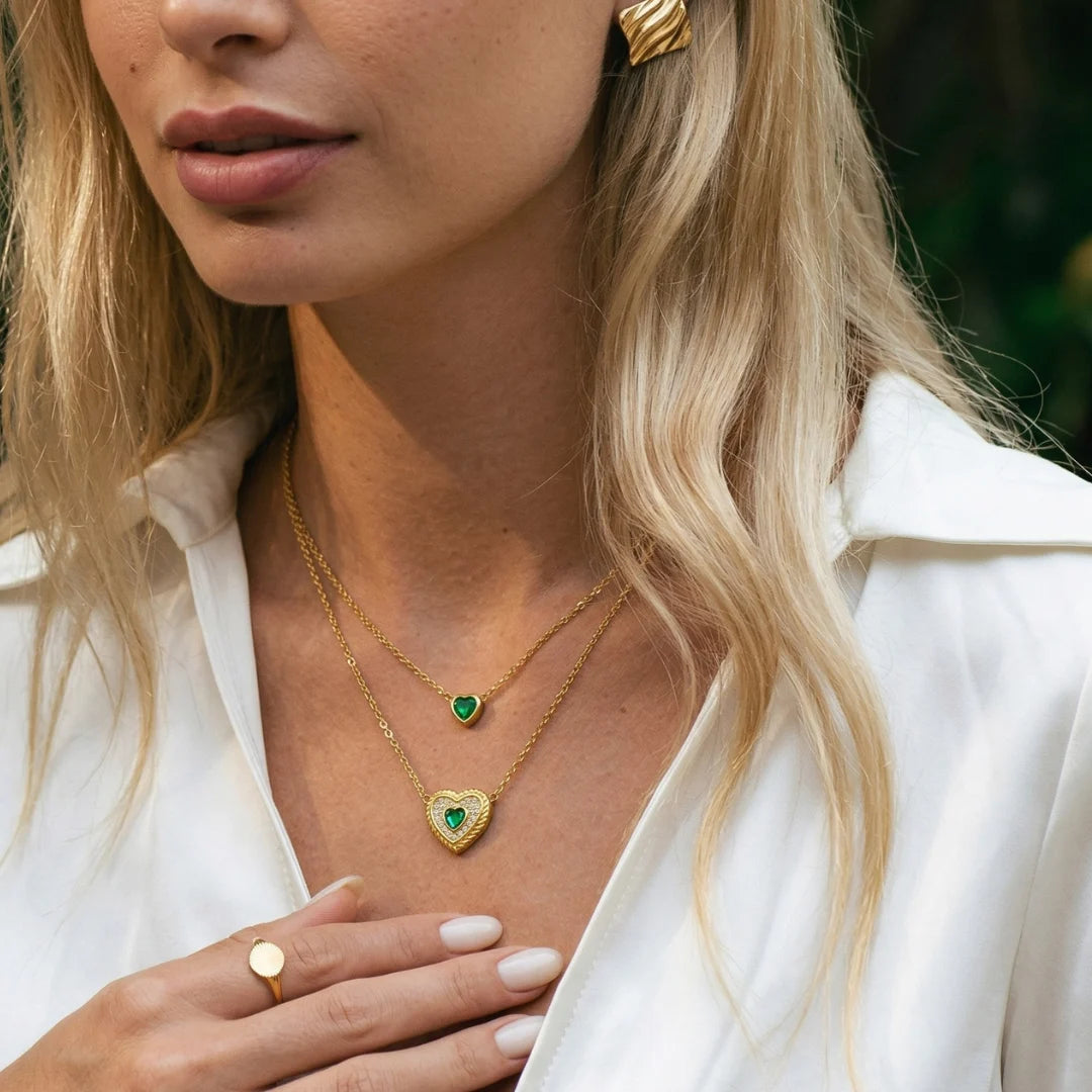 Emerald Heart Layered Necklace worn by a model in a white shirt with gold rings – layered necklace you can wear in the shower