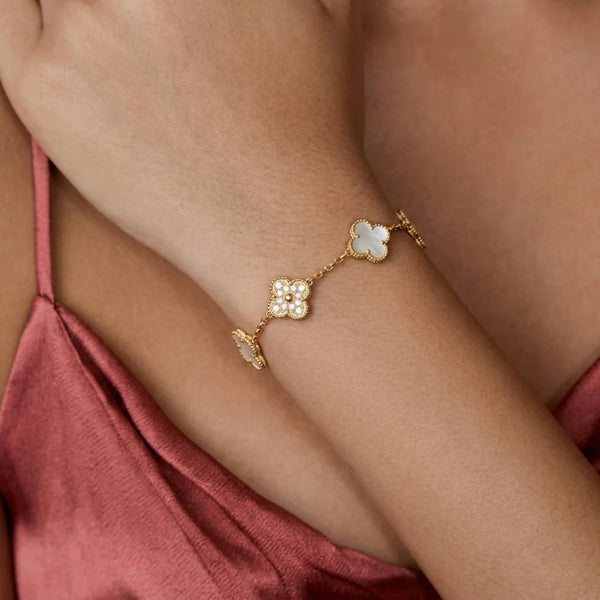 Five Clover Bracelet worn on the wrist with a pink satin top, waterproof gold clover bracelet