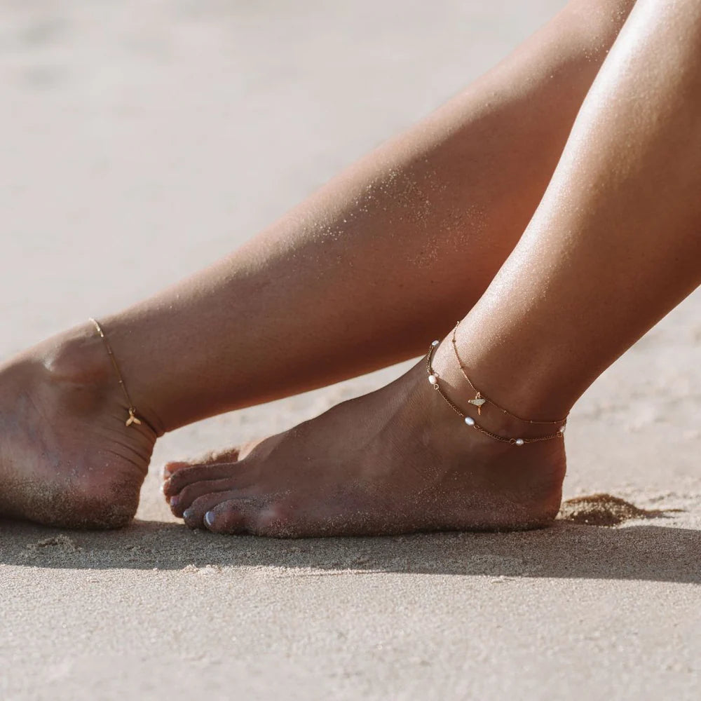 Freshwater Pearls Anklet worn on the ankle, legs crossed on sand – sweatproof, hypoallergenic anklet