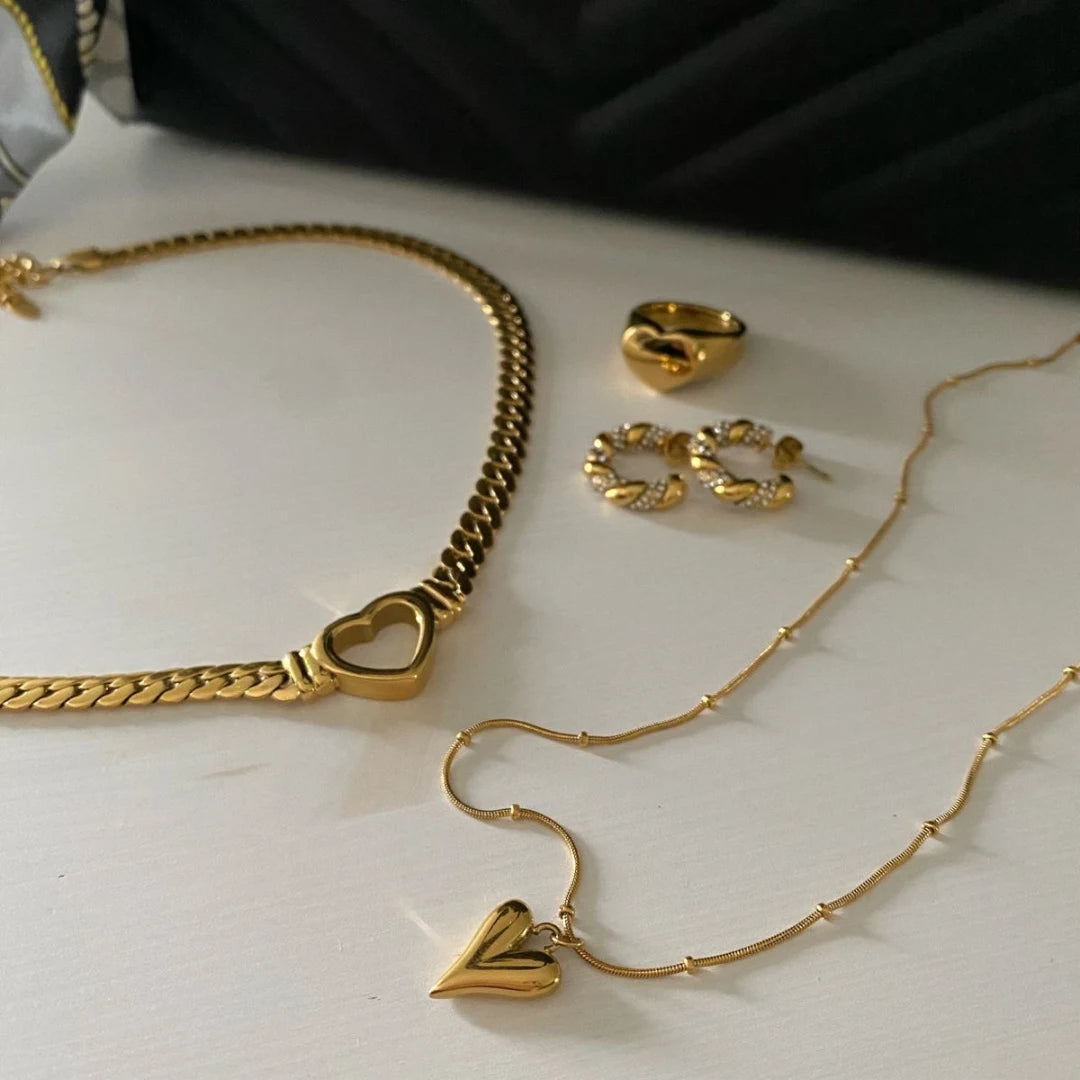 Heart Chain Necklace – necklace styled with matching gold jewellery on a table, chain necklace you can wear in the shower