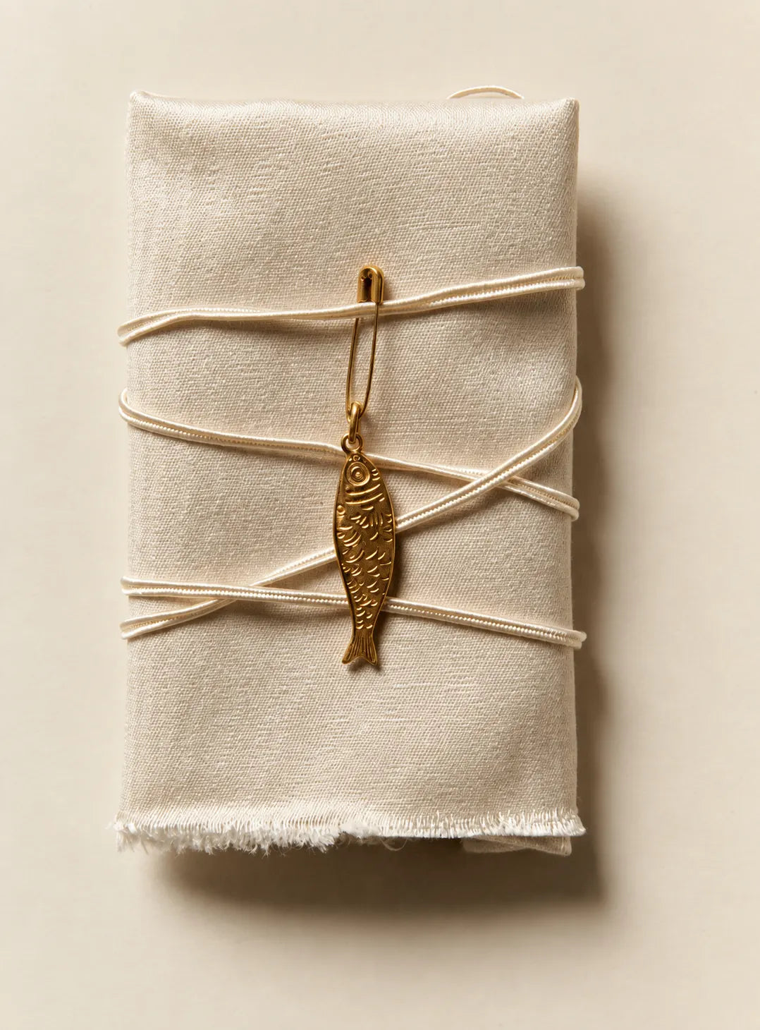 Lucky Fish Charm tied onto a wrapped parcel with string, waterproof gold charm