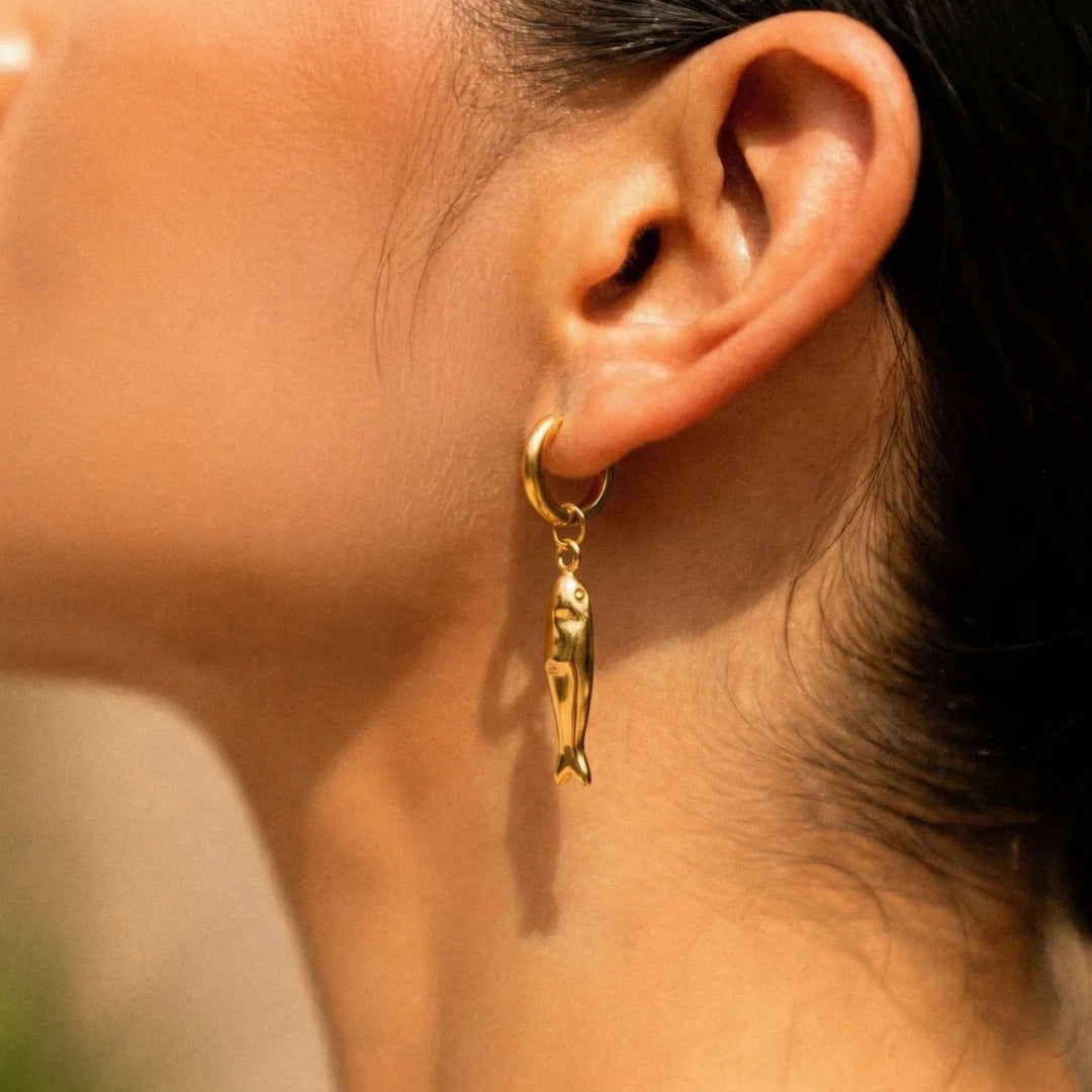 Matsya Hoops worn on the ear, close-up on the fish charm – hoop earrings you can wear in the shower