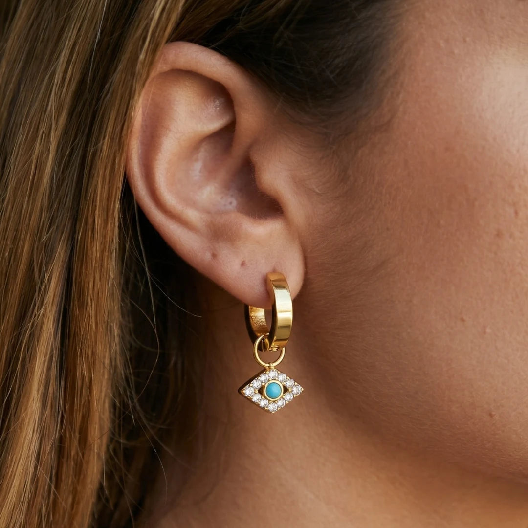 Nazar Charm Hoops worn on the ear, side view, 18K gold PVD