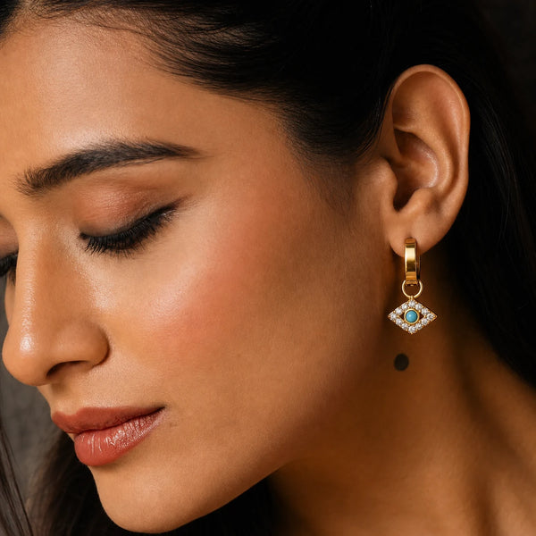 Nazar Charm Hoops worn by a model in profile, waterproof gold evil eye earrings