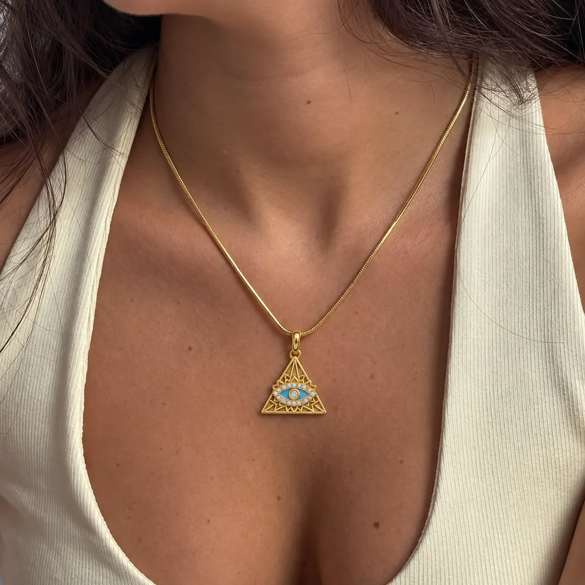 Nazar Pyramid Charm worn on a gold chain with a white top, waterproof gold charm