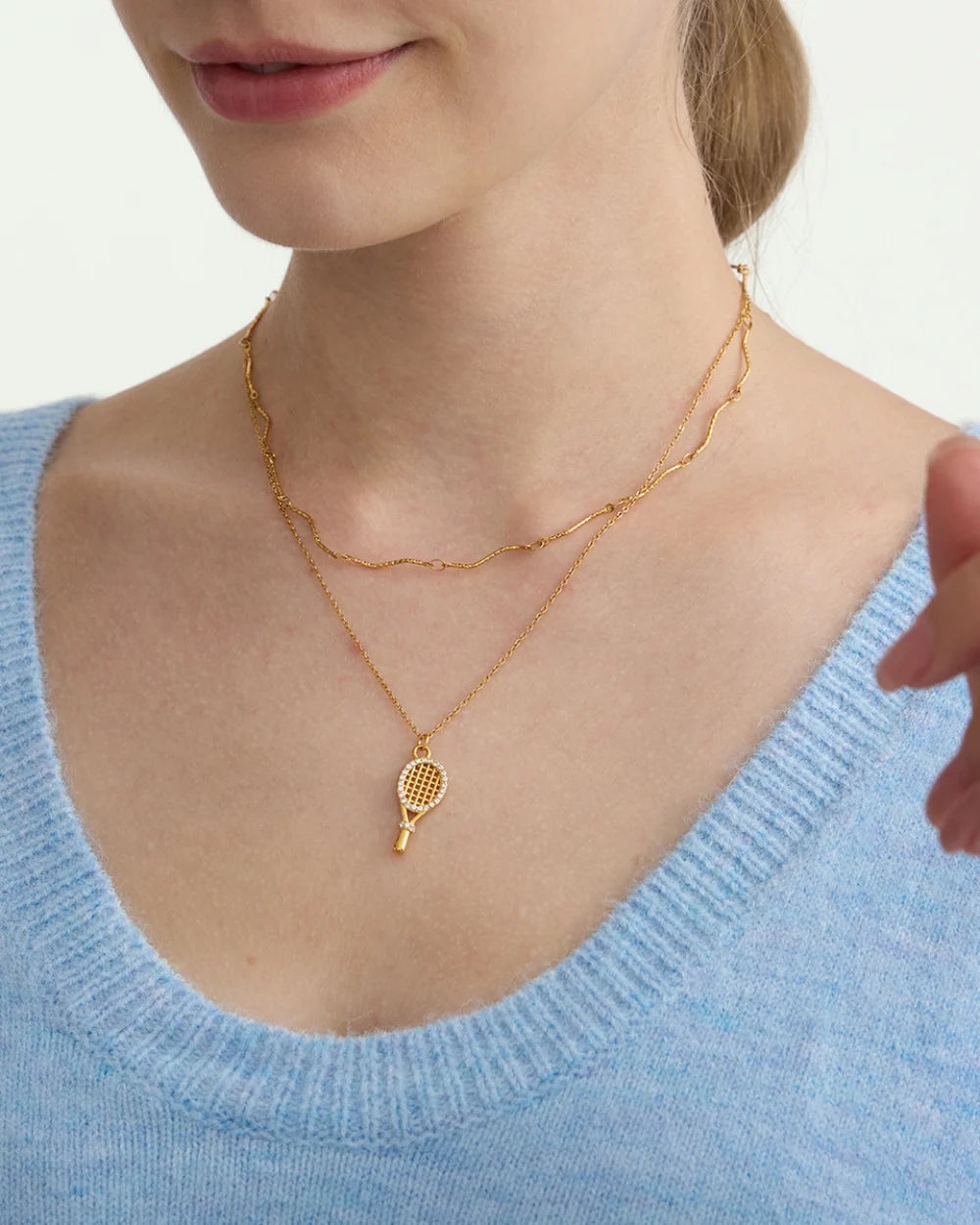 Pavé Tennis Racket Charm worn by a model with a blue top, 18K gold PVD