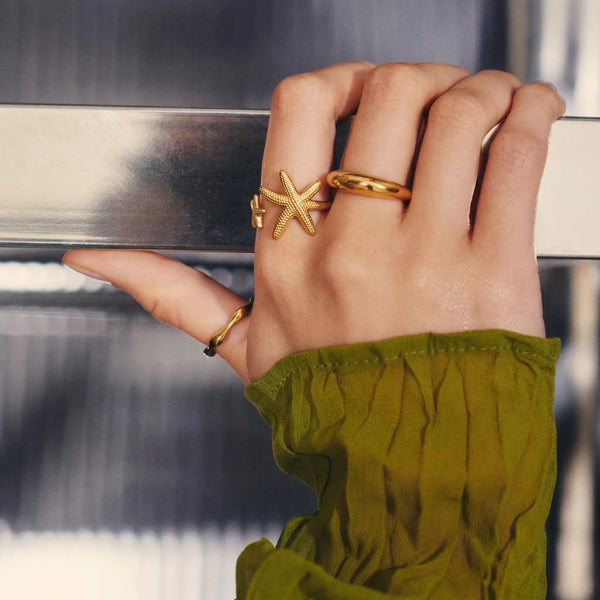 Starfish Ring worn on the hand with an olive knit sleeve – sweatproof, hypoallergenic open ring