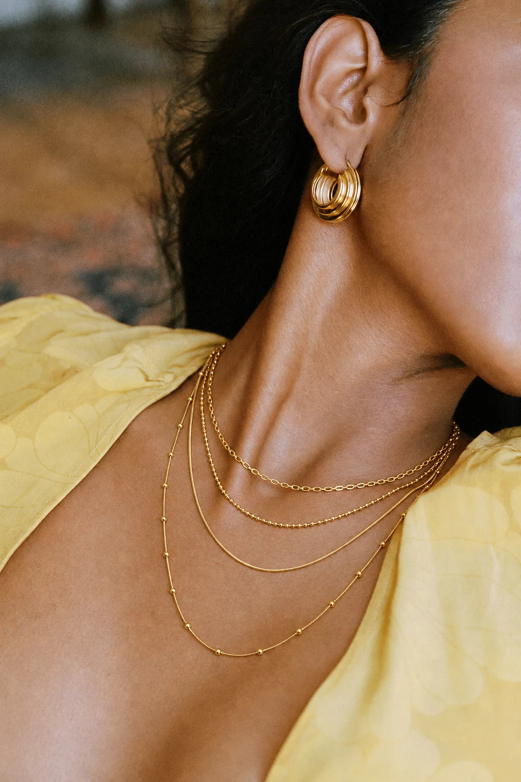 Trio Chain Layered Necklace worn by a model in profile with gold earrings – waterproof layered necklace for women in anti-tarnish 18K gold PVD | Priskel Jewellery