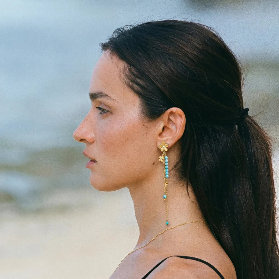 Turquoise Bloom Drop Earrings worn by a model at the beach – sweatproof, hypoallergenic drop earrings